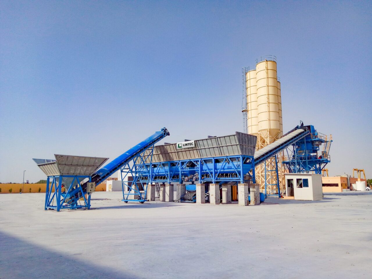 Blue framework and yellow silos of a Lintec facility to consider when you choose concrete batching plant.